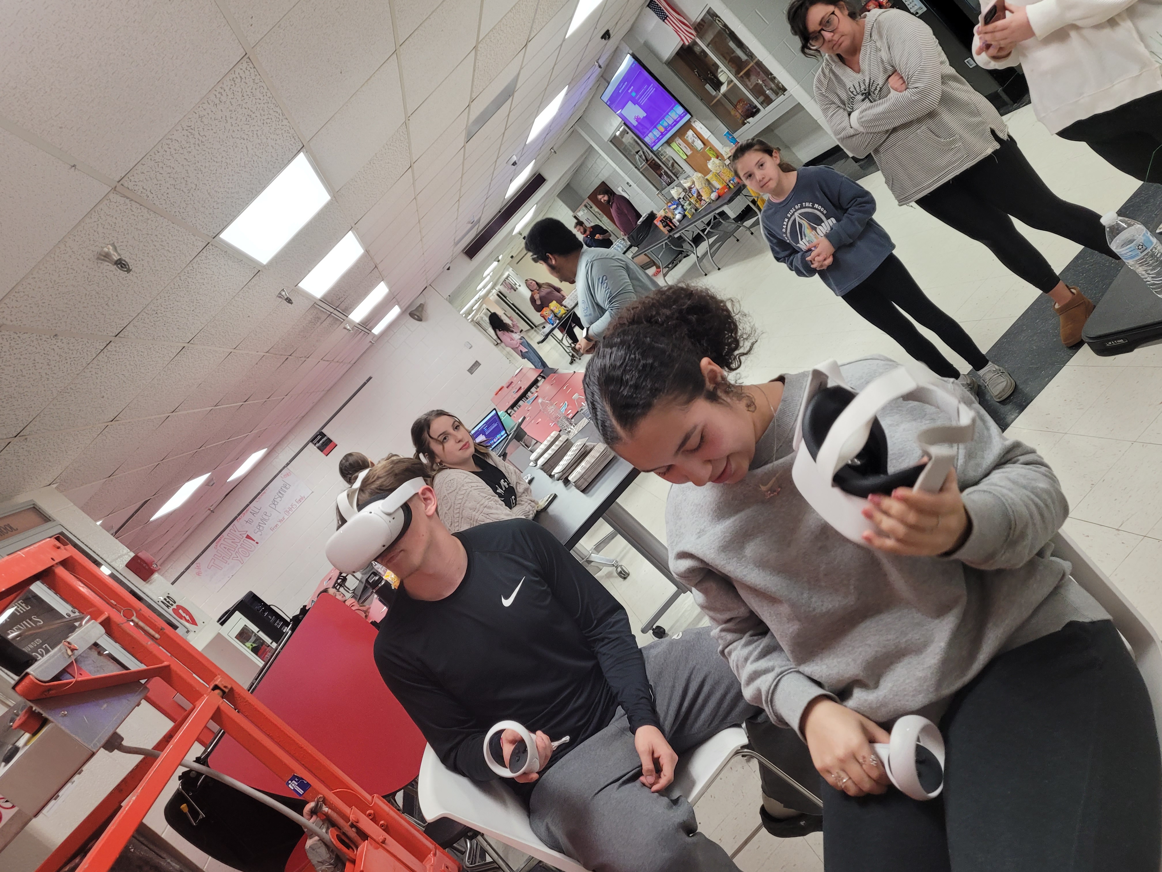 Students with VR goggles with other students behind observing.