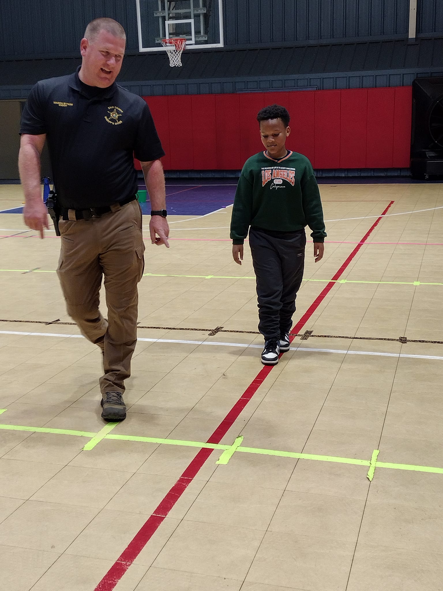 Local sheriff and participant presenting personal safety in obstacle course
