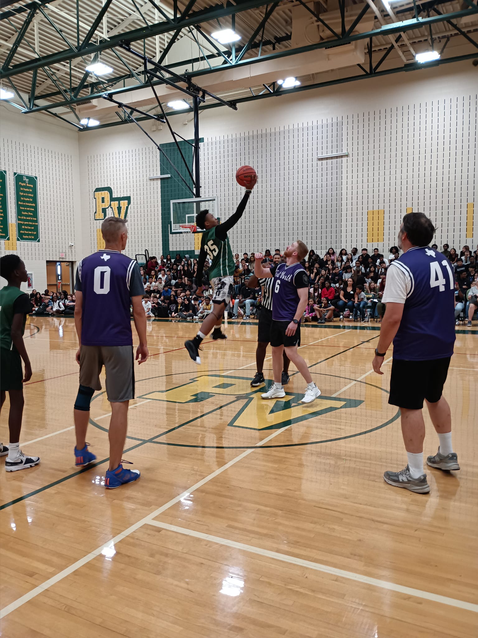 Team Kids receiving the ball during tip off in basketball game.